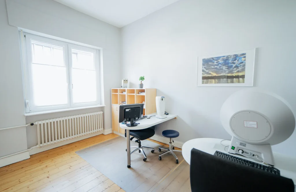 Ein helles Büro mit Schreibtisch, Computer und Pflanzen, ideal für kreative Arbeit und Meetings.